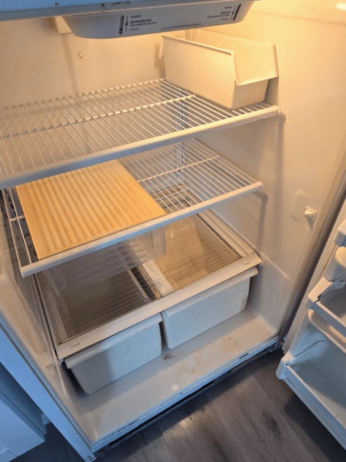 Refrigerator interior after deep cleaning, shelves wiped down and clear
